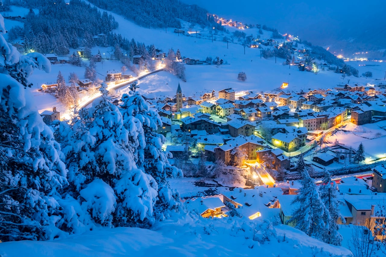 Fairy tale alpine village of Bormio and woods covered with snow at dusk, Sondrio province, Valtellina, Lombardy, Italy (Photo via Getty Images)
