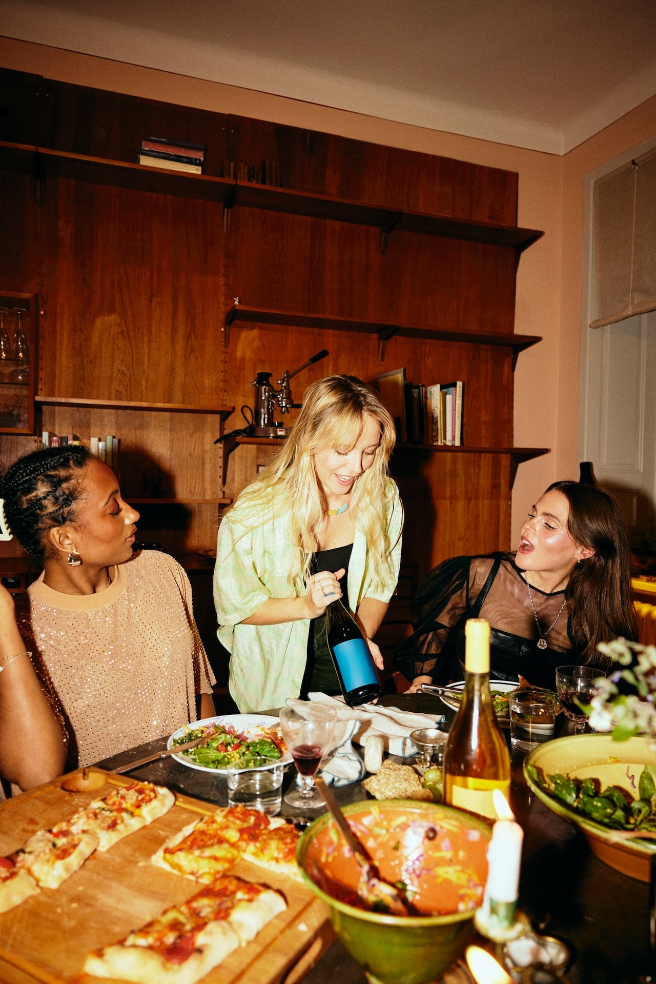 outgrowing friendships psychology; Woman serving wine to female friends sitting at dining table