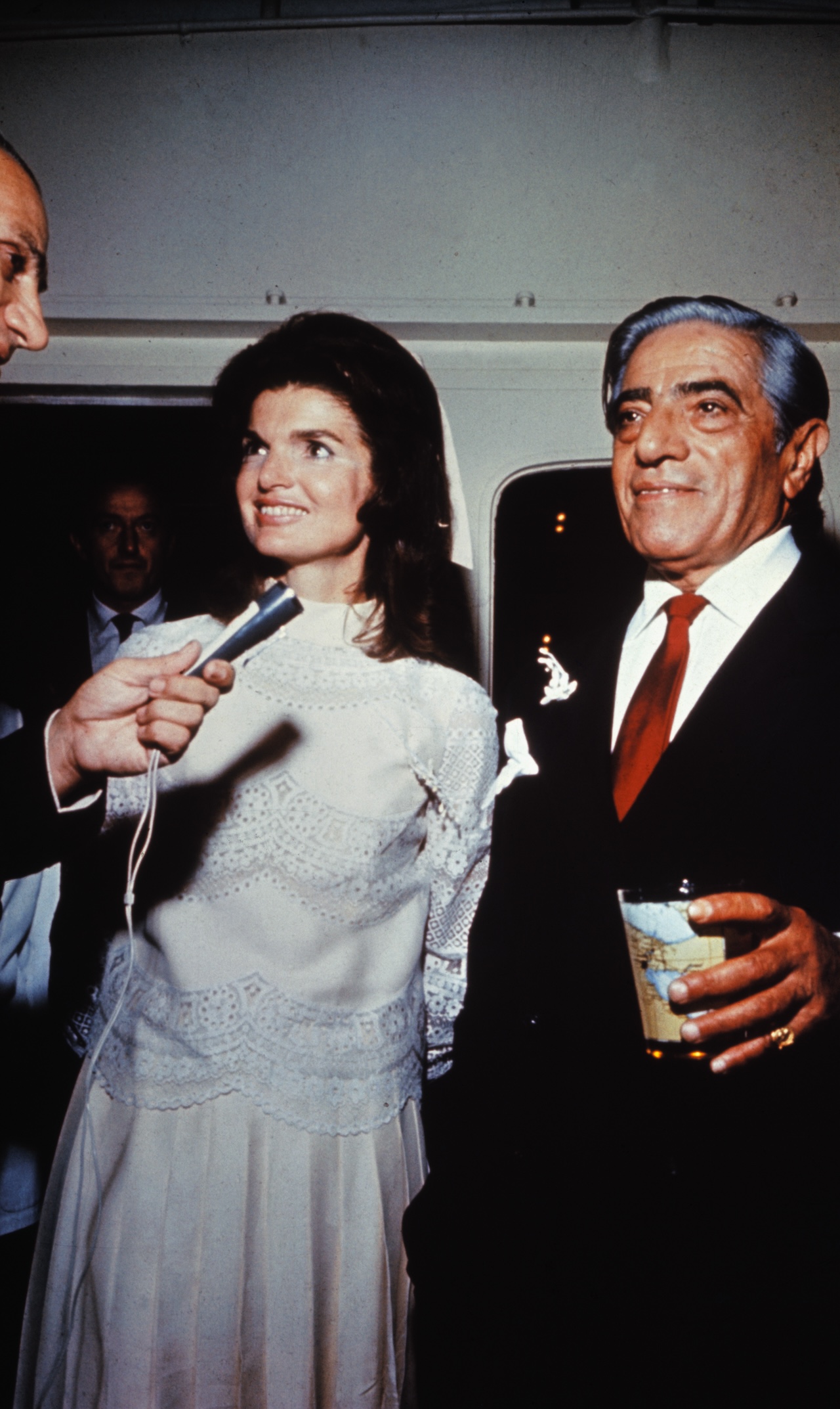 Aristotle Onassis married Jackie Kennedy on his private island. Onassis is shown with a drink in his hand and Jackie is smiling and talking into a microphone and wearing her white wedding dress. (Photo via Getty Images)