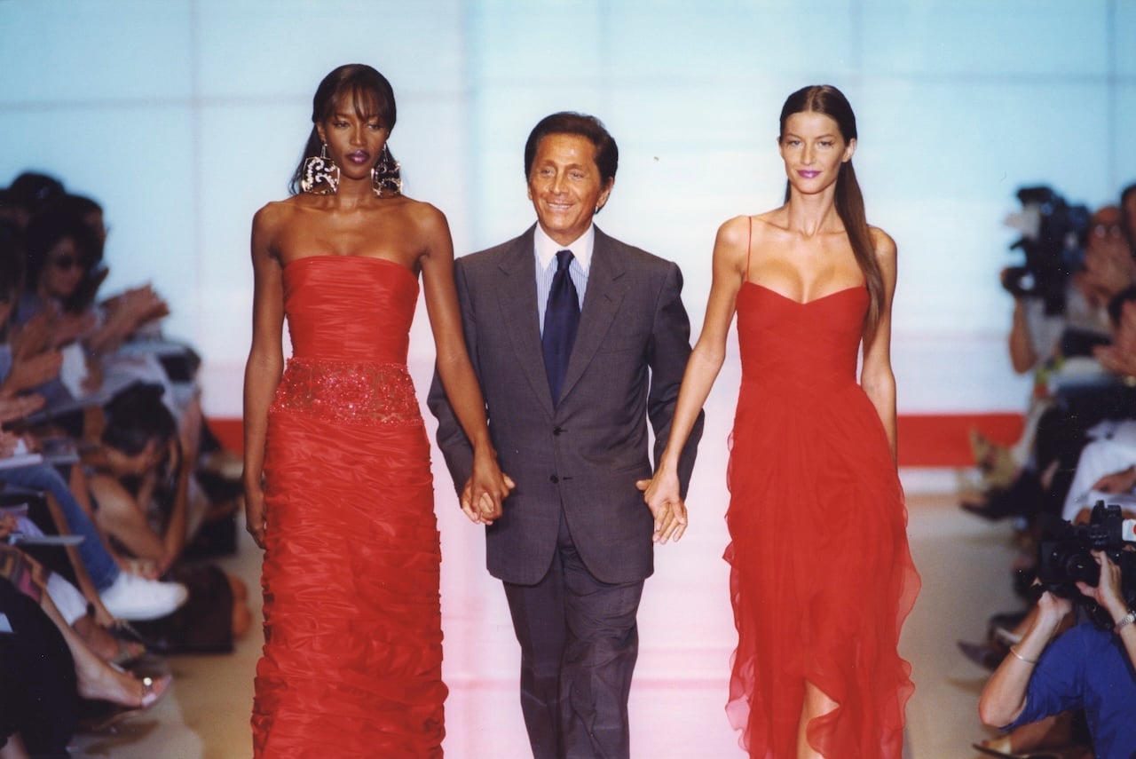 Le couturier Valentino défilent avec Naomi Campbell et Gisele Bündchen à la fin de son défilé Haute-Couture 1999/2000 à Paris en juillet 1999, France. (Photo by Pool ARNAL/CHARRIAU/Gamma-Rapho via Getty Images)