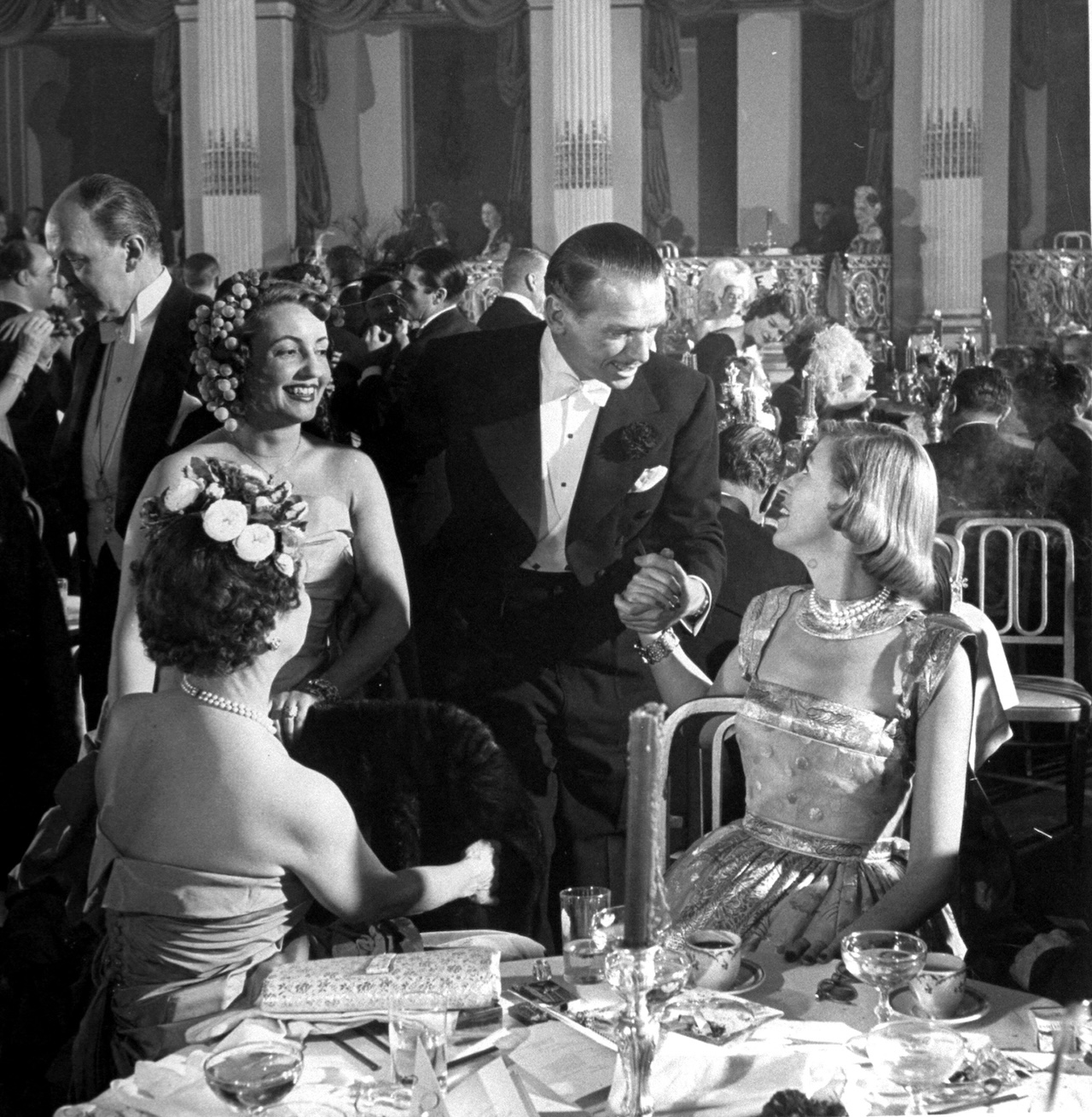 American actor Douglas Fairbanks Jr. (1909 - 2000) (second right) and his wife Mary Fairbanks (? - 1988) (standing, second left) talk with Mary Benedict Cushing (right) and Mary Benedict Cushing (formerly Mrs Vincent Astor, and known as Minnie) (left) at the Bal de Tete at Plaza Hotel, New York, New York, December 1948. (Photo by Bob Landry/Time Life Pictures/Getty Images)