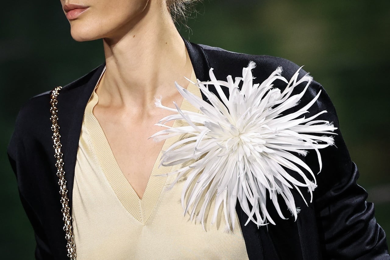 A model presents a brooch by Chanel for the Women Ready-to-wear Spring-Summer 2026 collection as part of the Paris Fashion Week, at the Grand Palais, in Paris, on October 6, 2025. (Photo by Anne-Christine POUJOULAT / AFP)