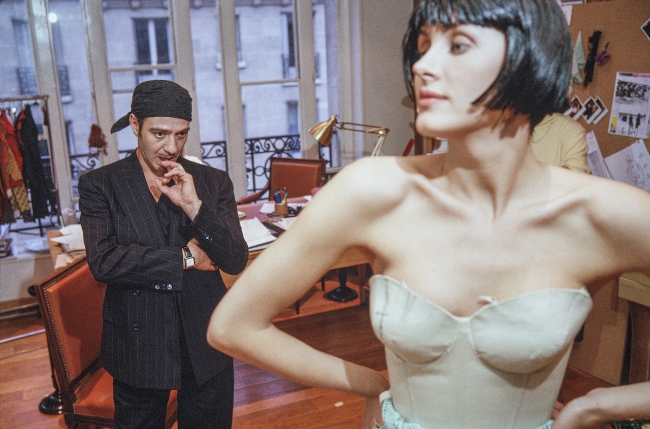 PARIS, FRANCE - 2005: British fashion designer John Galliano pictured working with a fashion model and assistants during a fitting session in the original former atelier of the legendary French fashion designer Christian Dior at the headquarters of the luxury fashion brand located on the Avenue Montaigne, Paris. (Photo by Derek Hudson/Getty Images)