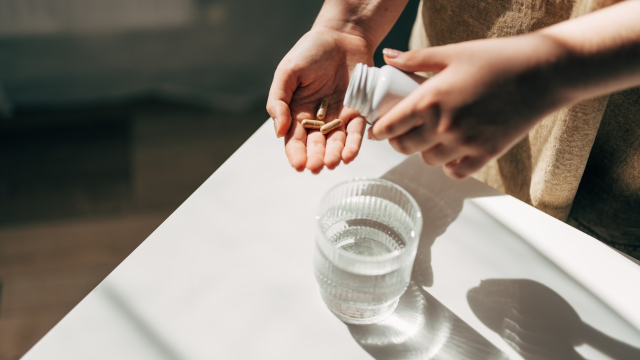 Woman holding supplement pills in her hand