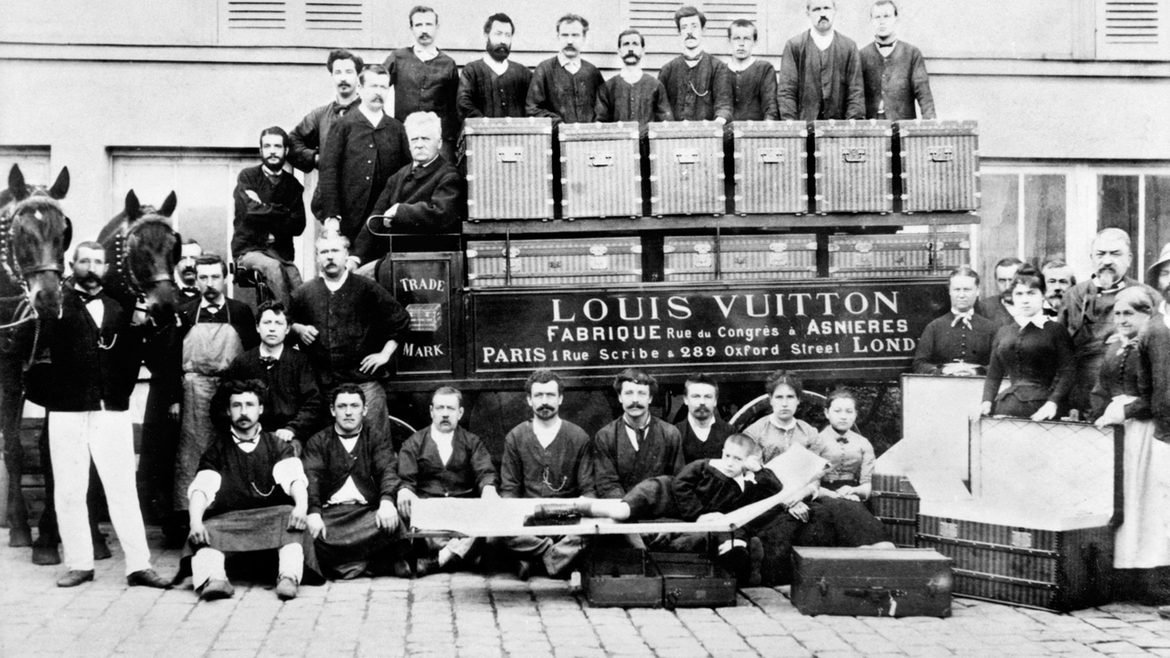 LOUIS-GEORGES-AND-GASTON-LOUIS-VUITTON -POSE-WITH-ARTISANS-IN-THE-COUNTRYARD-OF-THE-ASNIERES-SUR-SEINE-WORKSHOPS-ARCHIVES- LOUIS-VUITTON-MALLETIER-PANORAMA - Grazia